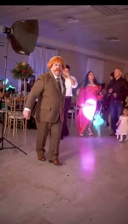 Central dancer and party guests in the Dime Dime Baby banquet-hall scene